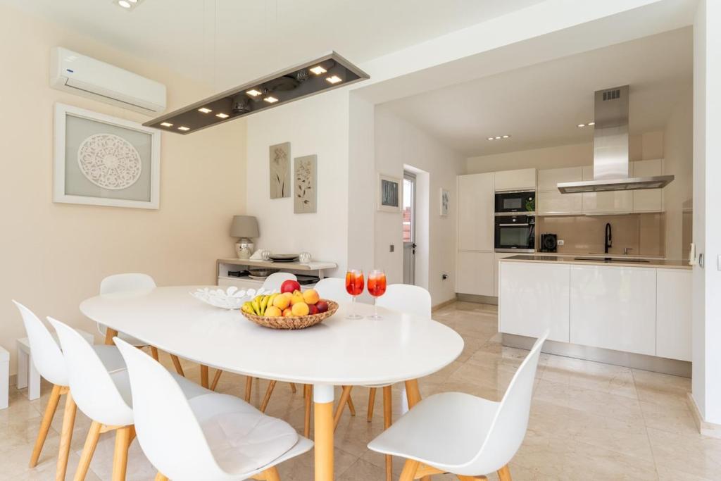 Una cocina y un comedor con una mesa y sillas blancas. en Private Villa Katarina Heated Pool Wi-fi BBQ in Tauro, en Mogán
