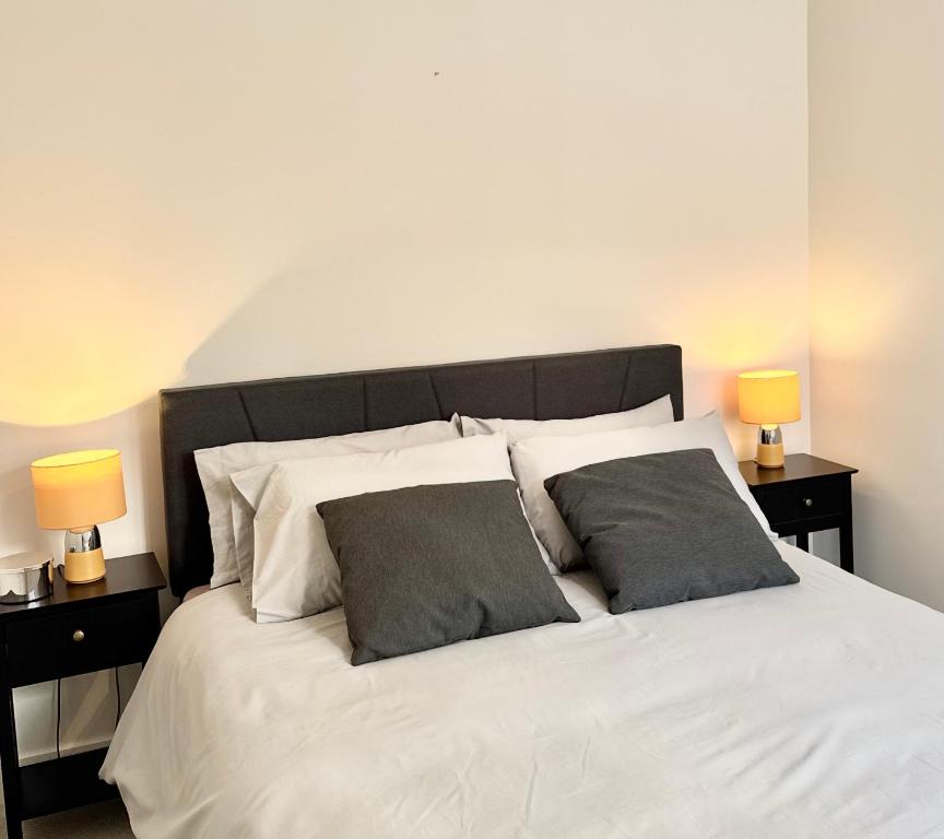 a bedroom with a white bed with two lamps at Brand-new flat, King Bed, Sofa Bed with full kitchen, Wi-Fi, self check-in Central location near everything in Farnborough