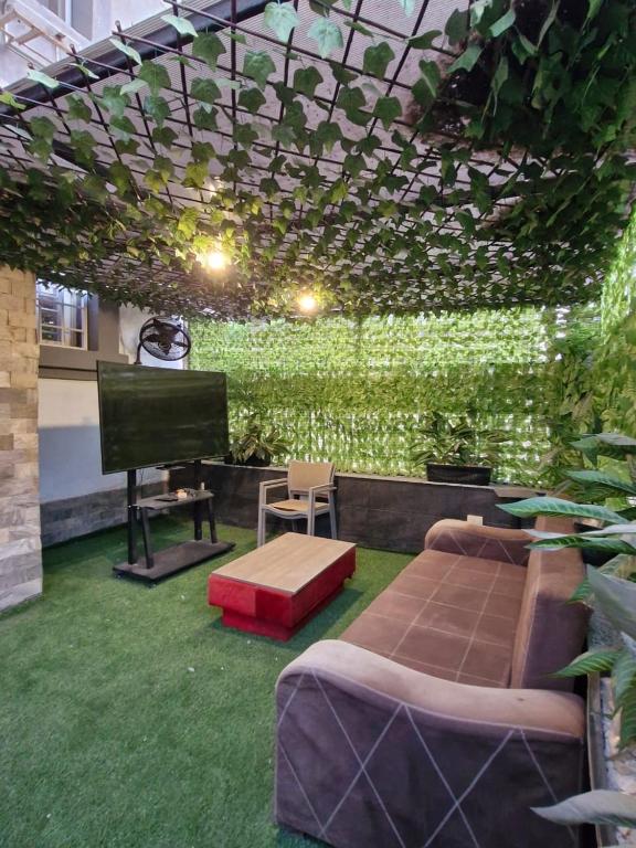 a room with a green wall with a couch and a tv at Gardinia City Apartment in Cairo