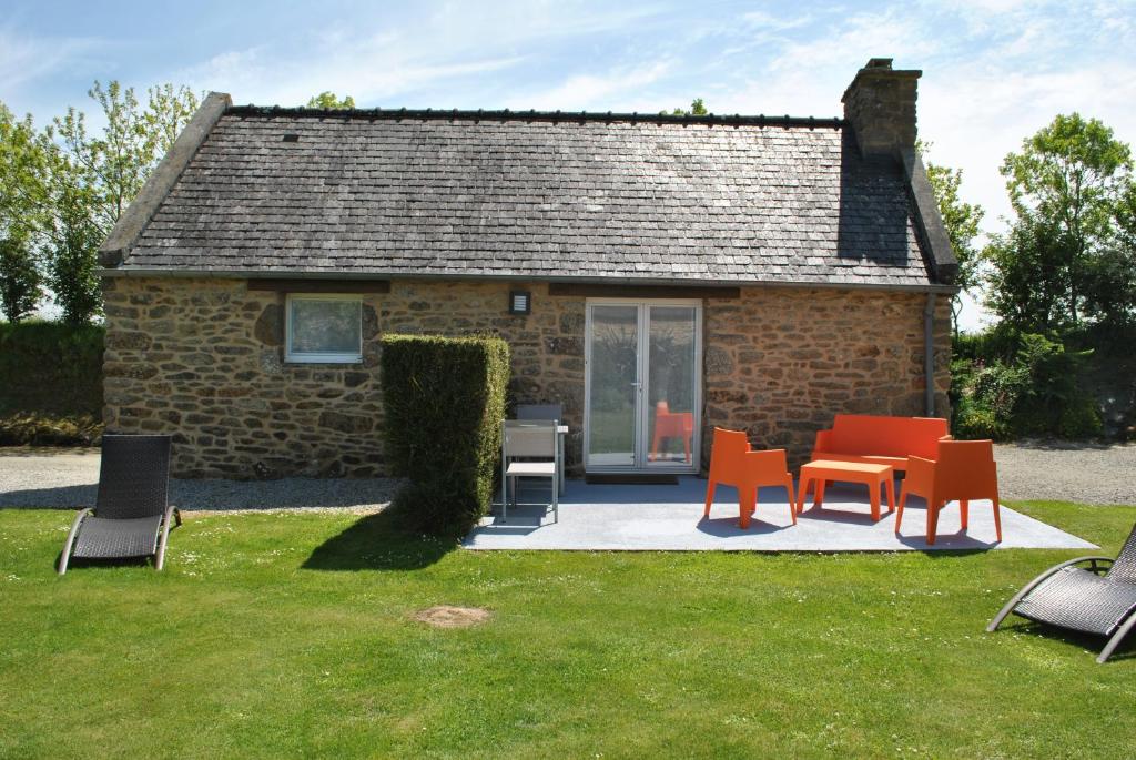 a group of chairs and tables in front of a building at Charmante Maison Bretonne avec Piscine Chauffée in Plouguin