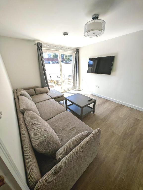 a living room with a couch and a flat screen tv at Cozy corner 2 bedroom house in Edinburgh