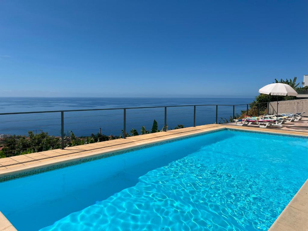 a swimming pool with a view of the ocean at Casa Vista do Ledo in Arco da Calheta
