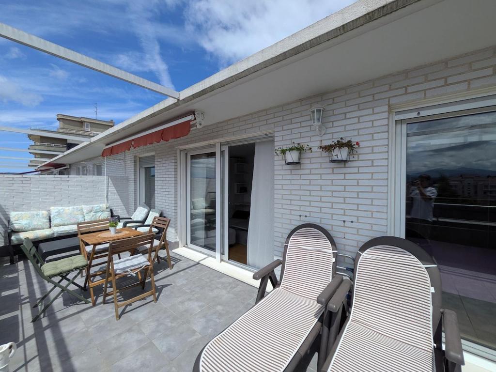 a patio with a table and chairs on a balcony at Apartamento Carmen y Adolfo in Laredo