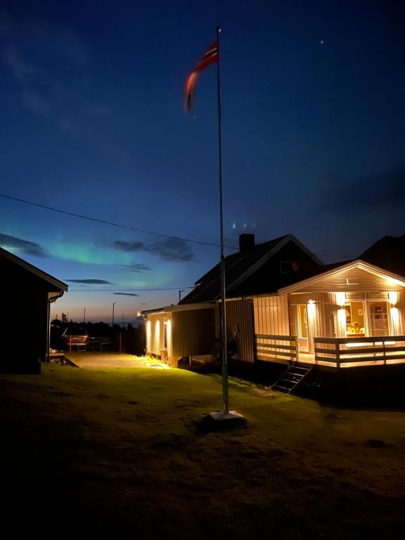 a flag pole in front of a building at night at Koselig hus nær sjø og fjell in Nord-Lenangen