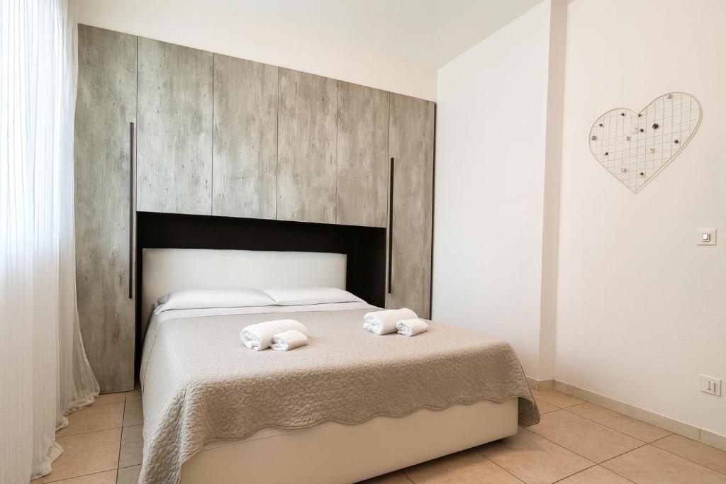 a bedroom with a bed with two towels on it at Sea la vie Sabbiadoro apartment in Lignano Sabbiadoro