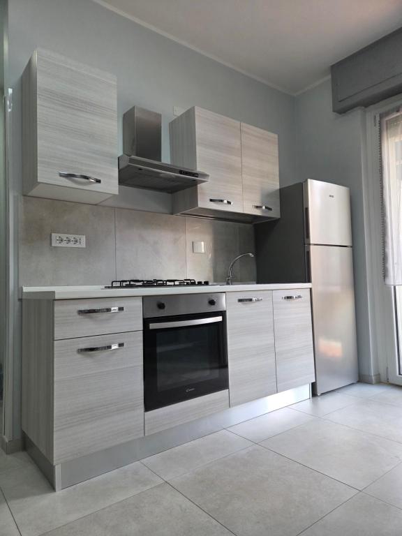 una cocina con estufa y refrigerador en Ceriale Suite, en Ceriale