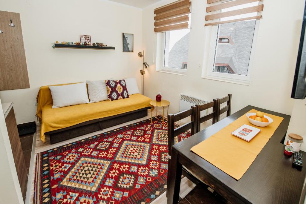 a small living room with a table and a couch at Apartman No.32a-JollyKop in Kopaonik
