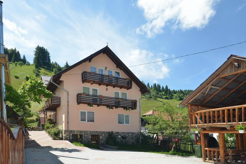 ein Haus mit Balkon an der Seite in der Unterkunft Vila Moecel in Moieciu de Sus