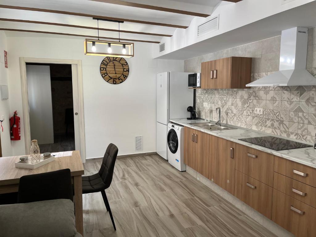 a kitchen with a table and a dining room at Apartamentos Rurales El Rincón de la Sierra 