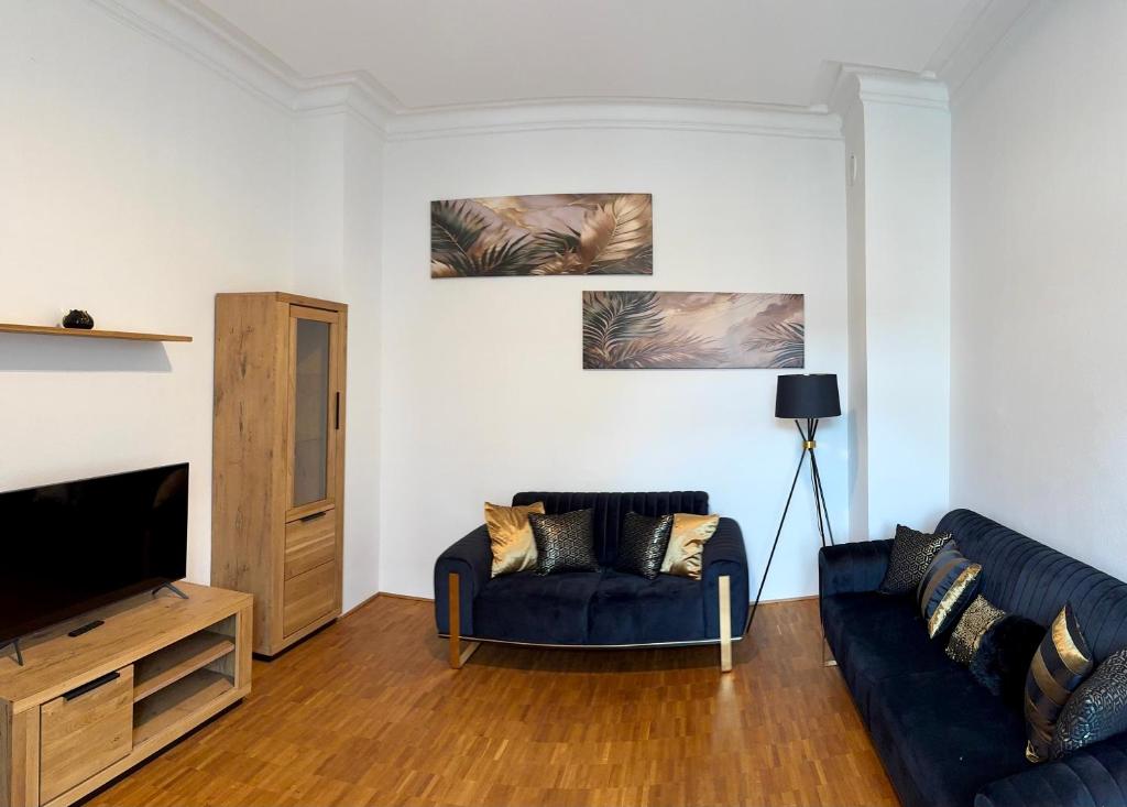 un soggiorno con un divano blu e una TV di Boutique Apartment LIMONIA - Historic Heart of Ulm a Ulma
