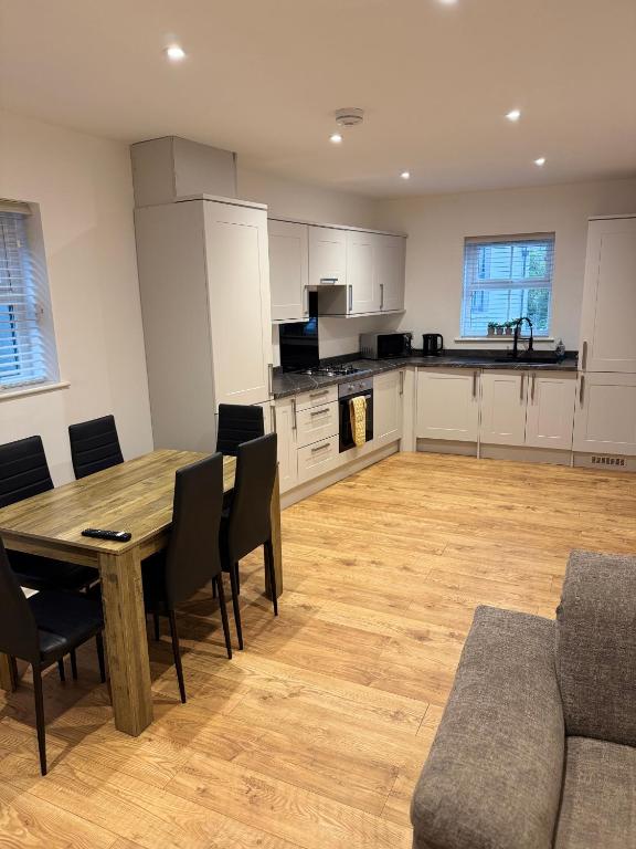 a kitchen and dining room with a wooden table and chairs at 3 Bedroom House with free on site Parking next to the Canal in Keighley