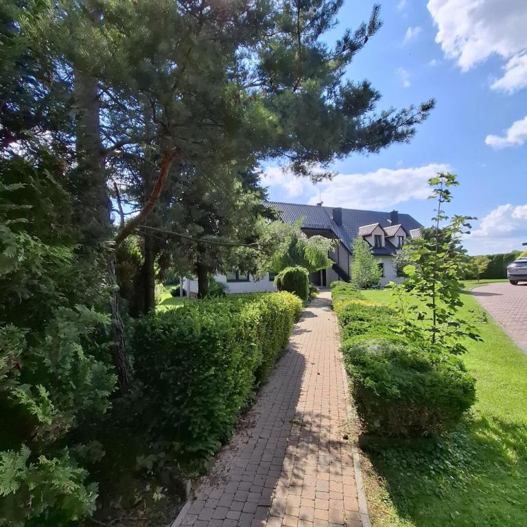 a walkway in front of a house with a tree at Apartamenty TUTERRA IV in Zabagnie