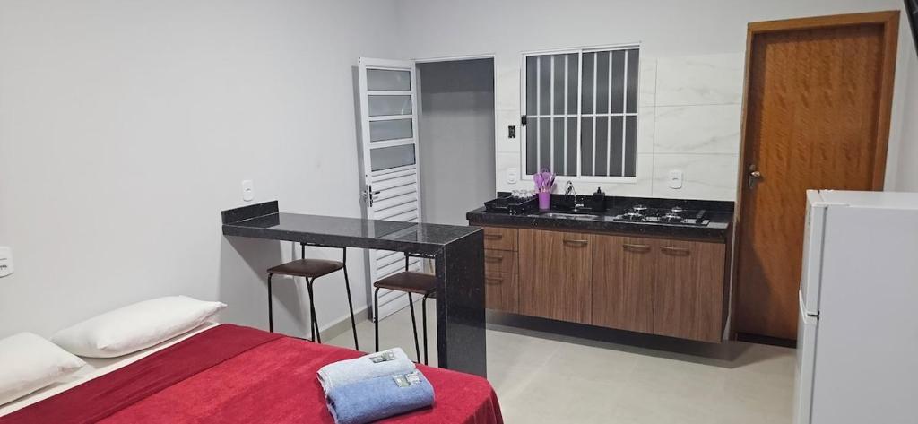 a bedroom with a bed and a kitchen with a counter at kitnet 8 Paulista Douglas · Loft 8 Espaço Inteiro Vista para o PQ Ecológico in Indaiatuba