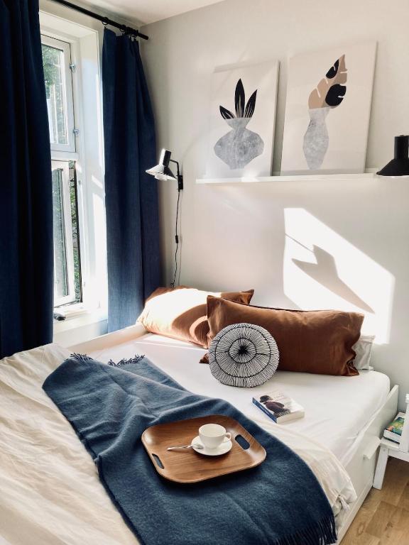 a bed with a tray and a plate on it at Refined and Ultra-Central Apartment Studio in Oslo