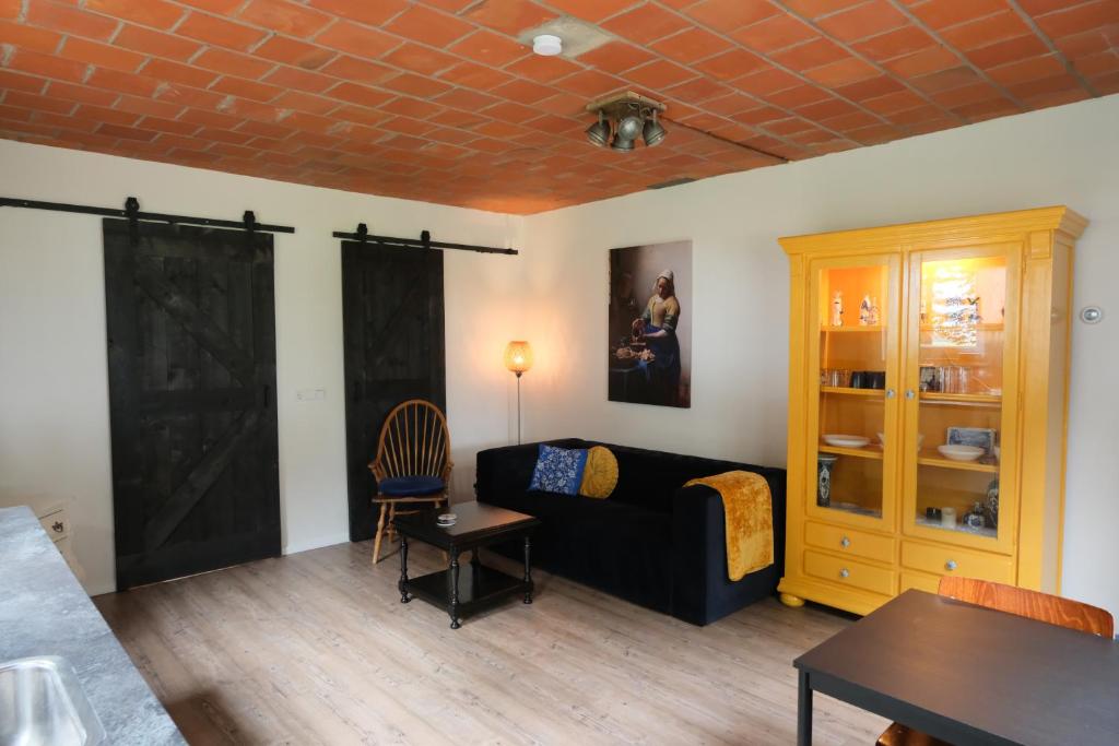 a living room with a couch and a table at Boerderij de Windroos in Tollebeek