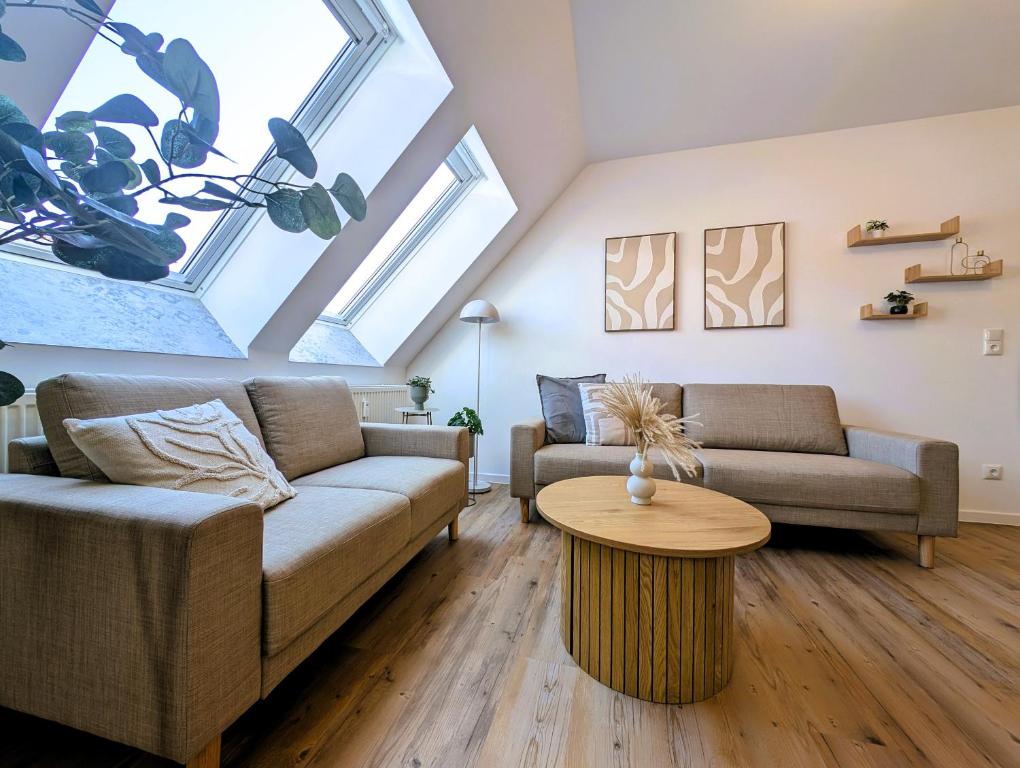 een woonkamer met twee banken en een tafel bij BohnApartments Schiller 7- Penthouse- WLAN- Parking- citynah in Erfurt