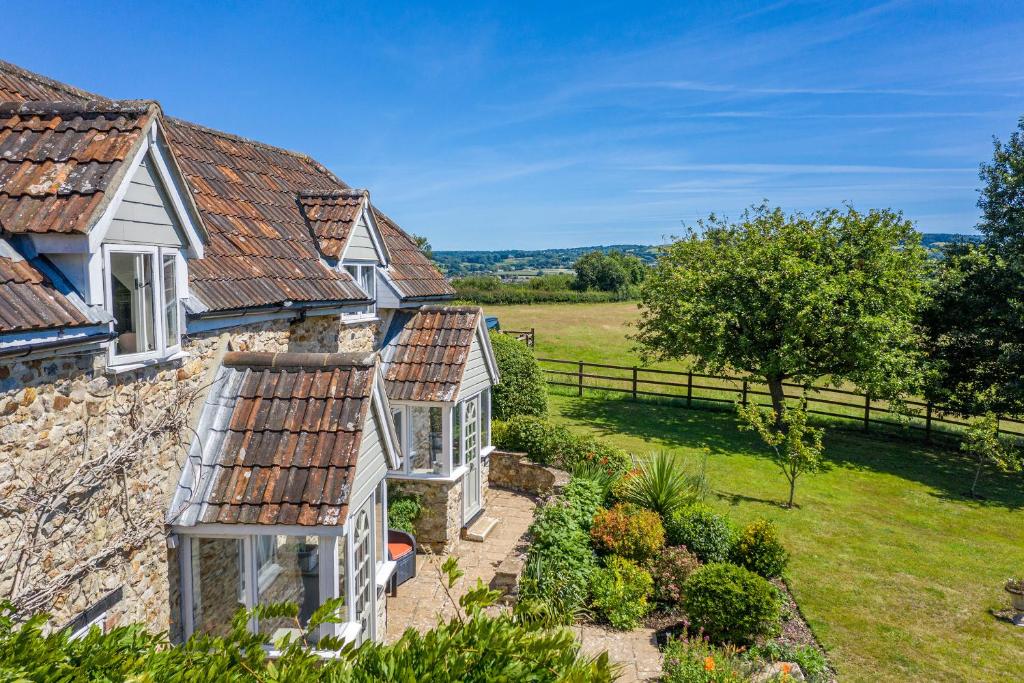 een uitzicht op een huis met een tuin bij Valley Farm Holiday Cottages in Axminster