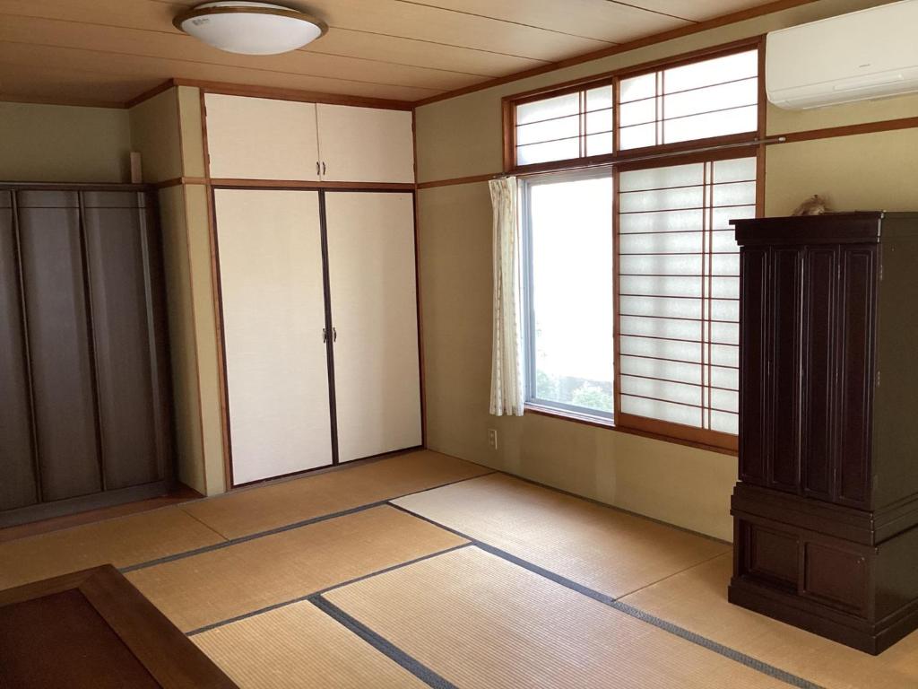 an empty living room with two windows and a cabinet at Ichihara city house - Vacation STAY 20067 in Ichihara