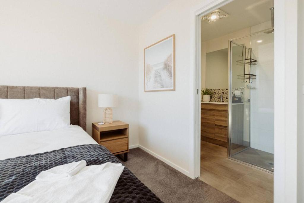 une chambre avec un lit et une douche en verre dans l'établissement The Drift Haus- Shearwater, à Port Sorell