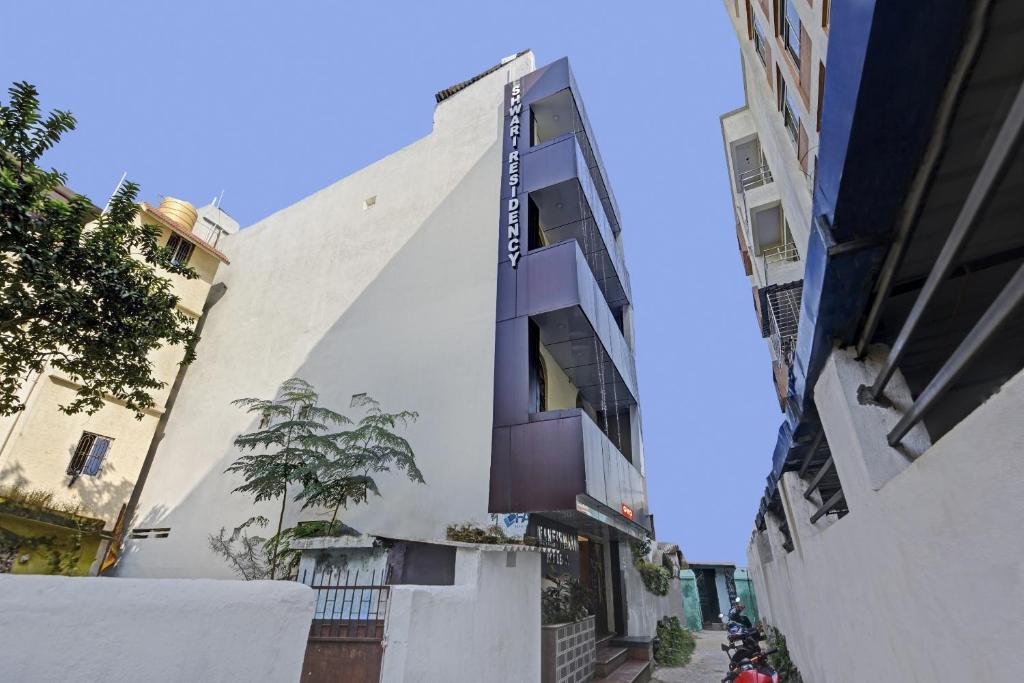 a white building with a balcony on a street at Hotel O Maheshwari Residency in Rānchī
