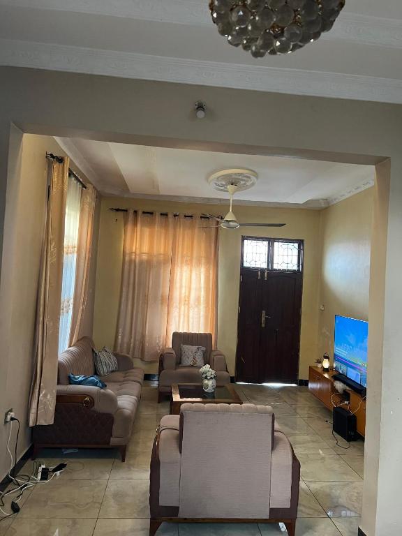 a living room with couches and a flat screen tv at Mashingo Homestay in Dar es Salaam