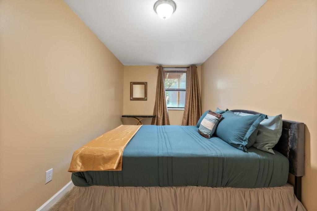 Cette petite chambre comprend un lit avec des oreillers bleus. dans l'établissement Cozy Two Bedroom in Brooklyn, à Brooklyn
