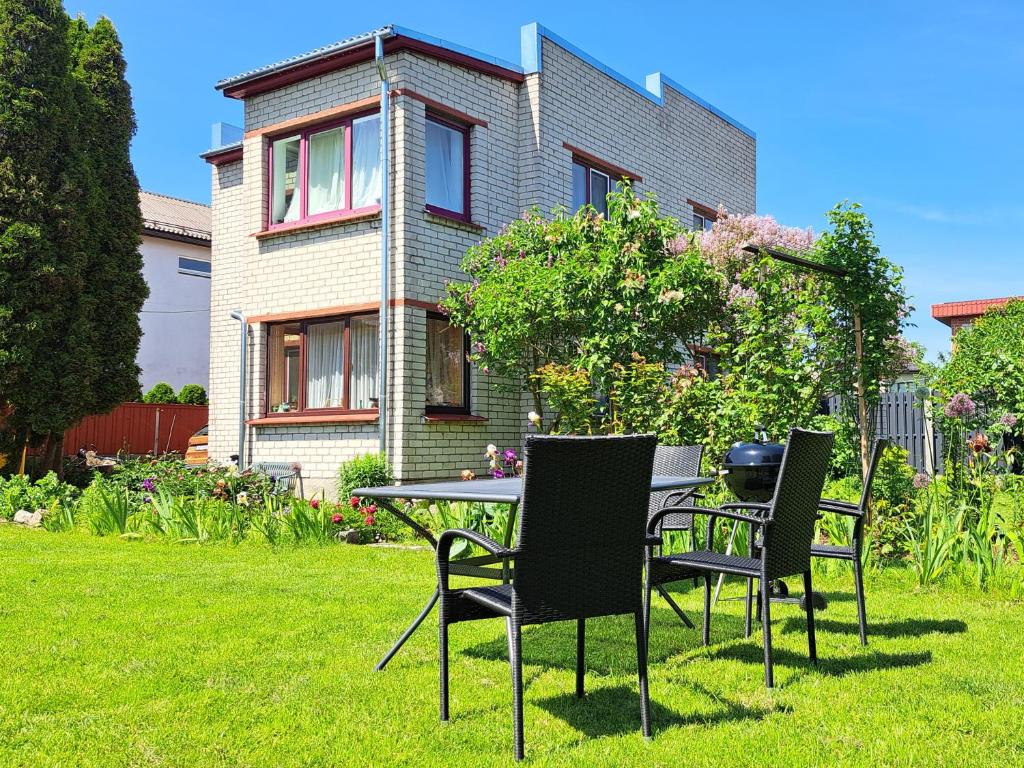 a table and chairs in front of a house at Liepājas brīvdienu māja ar dārzu in Liepāja
