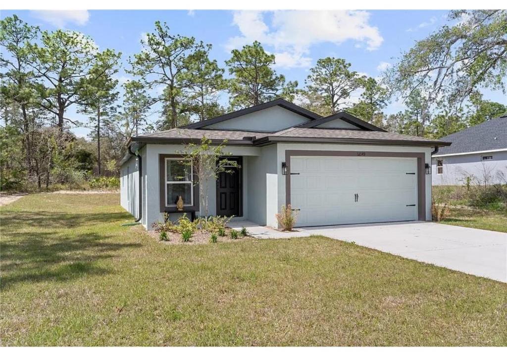 a house with a garage in a yard at Comfortable Executive Villa in Brooksville
