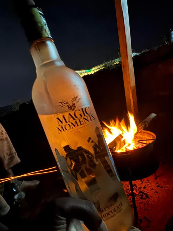 a bottle of alcohol sitting next to a fire at Vales Room in Mpigi