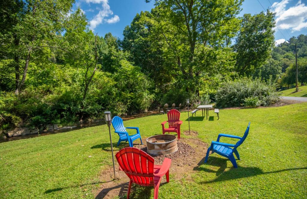 a group of colorful chairs sitting in the grass at New River Farmhouse on the New River & Stocked Fishing Creek in Crumpler