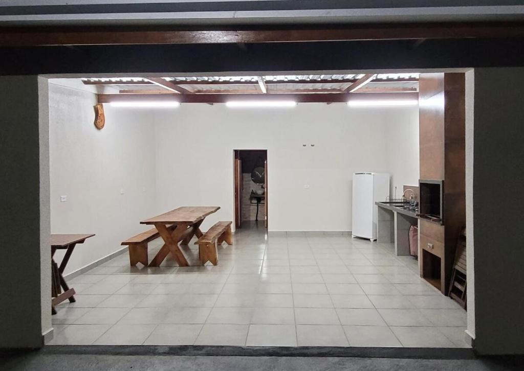 a room with a table and benches in a kitchen at Edícula Roma - Casa de hóspedes in Campo Mourão