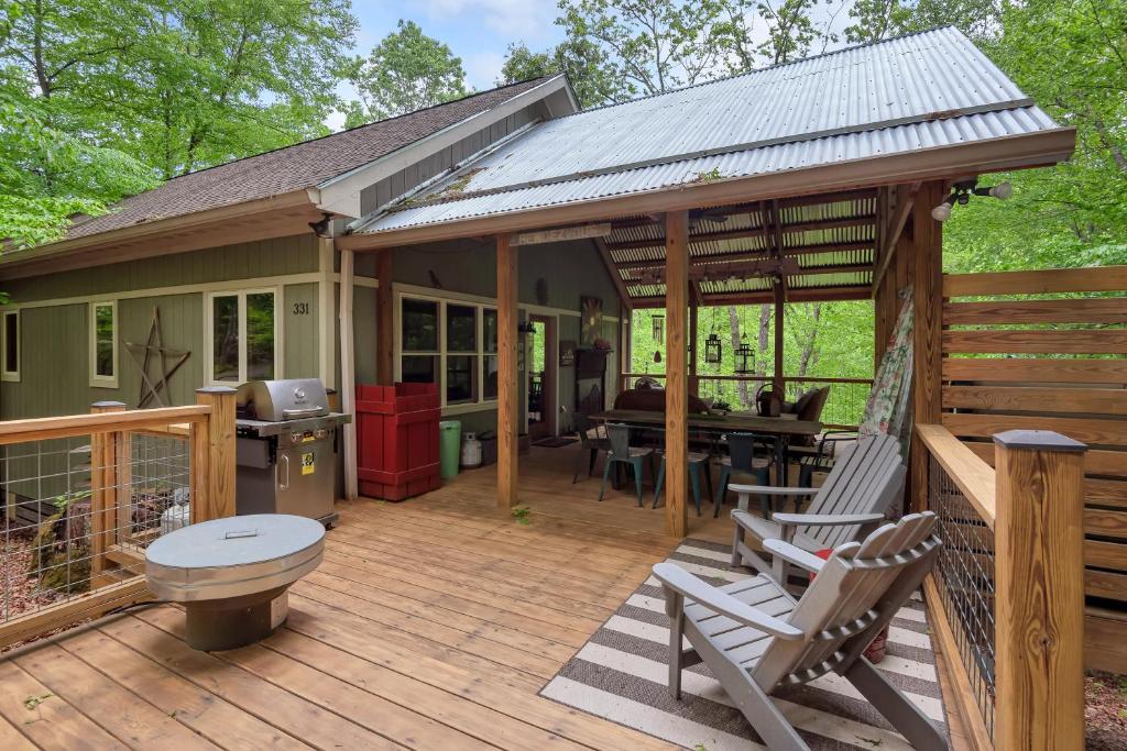 a wooden deck with a kitchen and a house at By The New River - Hot Tub - Fireplace - Covered Porch in Glendale Springs