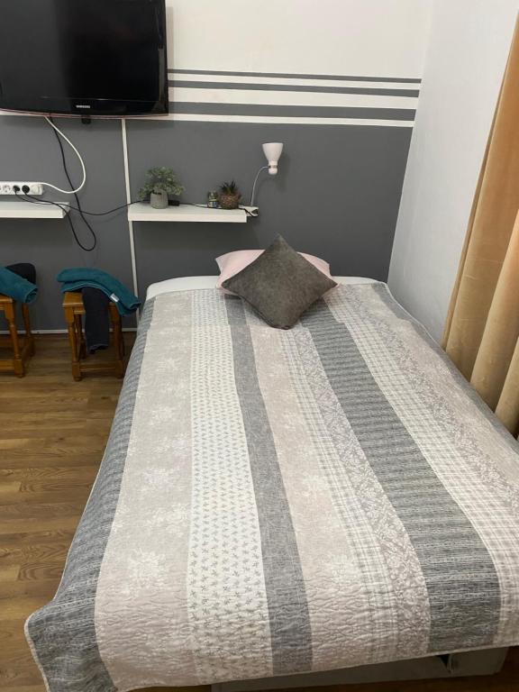 a bedroom with a bed with a pillow on it at Feniks apartman in Apatin