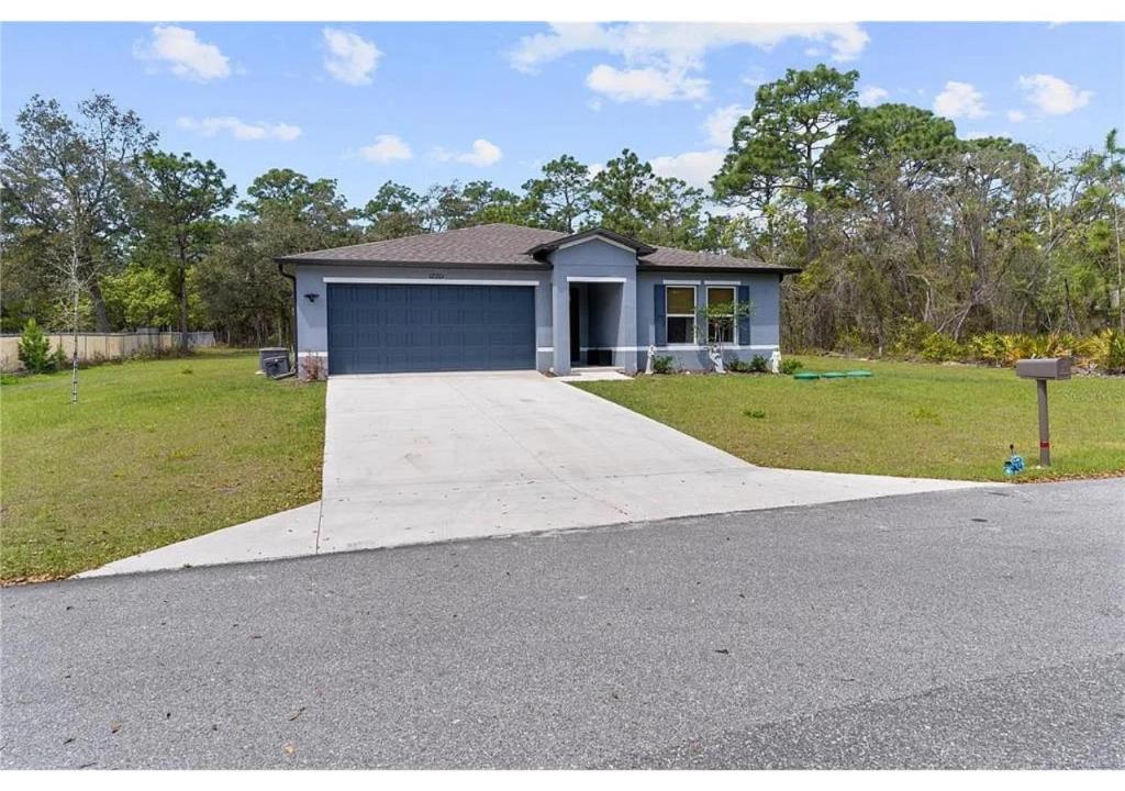 a house with a garage and a driveway at Stylish Home Away From Home in Brooksville