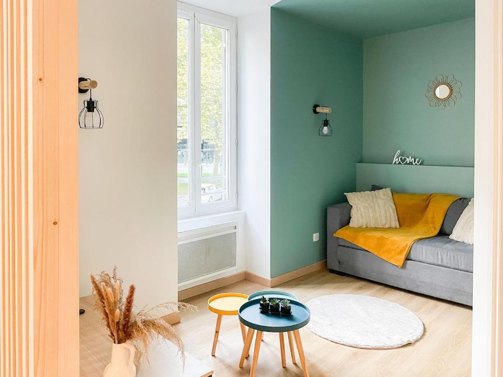 a living room with a couch and a table at Cocon design centre ville proche gare in Mâcon