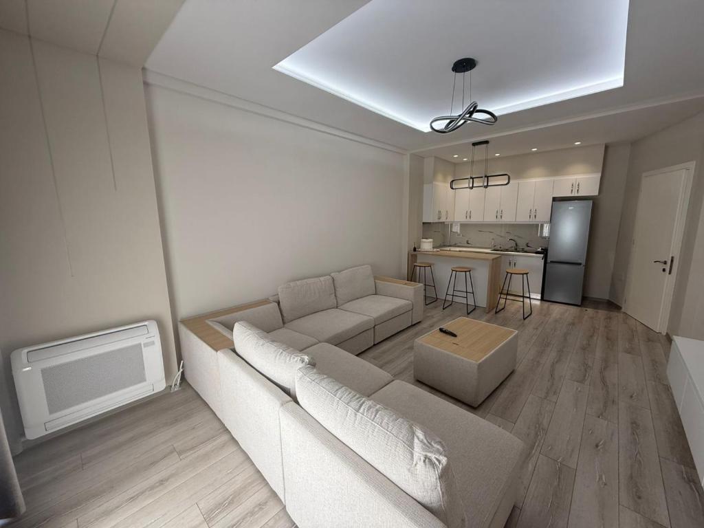 a living room with a couch and a kitchen at Amaji Apartament Korcë in Korçë