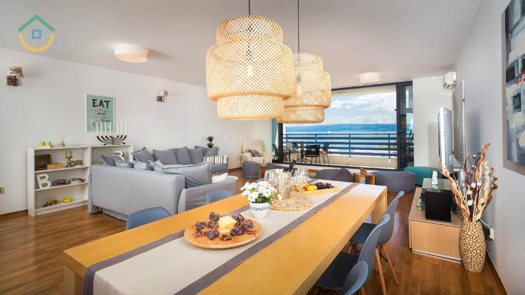 ein Esszimmer und ein Wohnzimmer mit einem Tisch mit Essen drauf in der Unterkunft Sun Spalato Views in Split