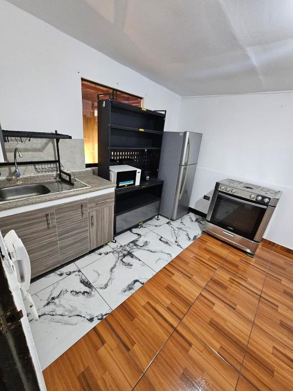 a kitchen with a smashed up floor with a refrigerator at Departamento para 4 Personas in Lima