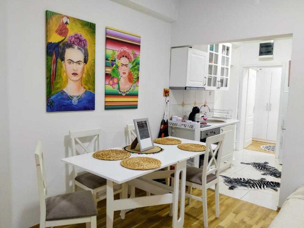 una cucina bianca con tavolo e sedie bianchi di Frida Apartment a Ohrid