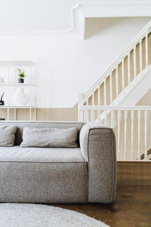 a couch in a living room with a staircase at Staal House in Amsterdam