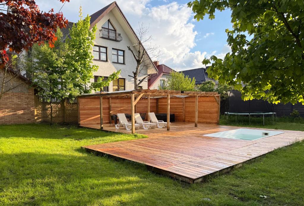 une arrière-cour avec une terrasse en bois et une piscine dans l'établissement Dom wakacyjny Zwierzyniec, à Zwierzyniec