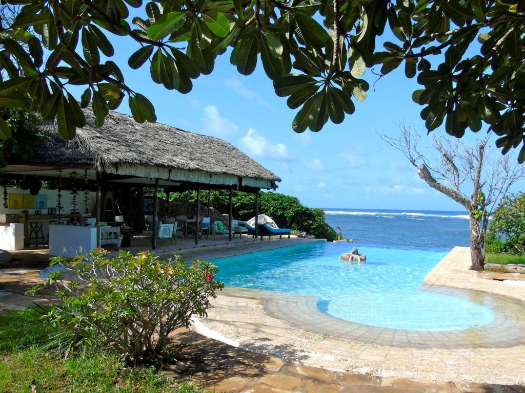a pool at a resort with people in the water at Self catering Beach House on award winning marine conservancy in Kijangwani