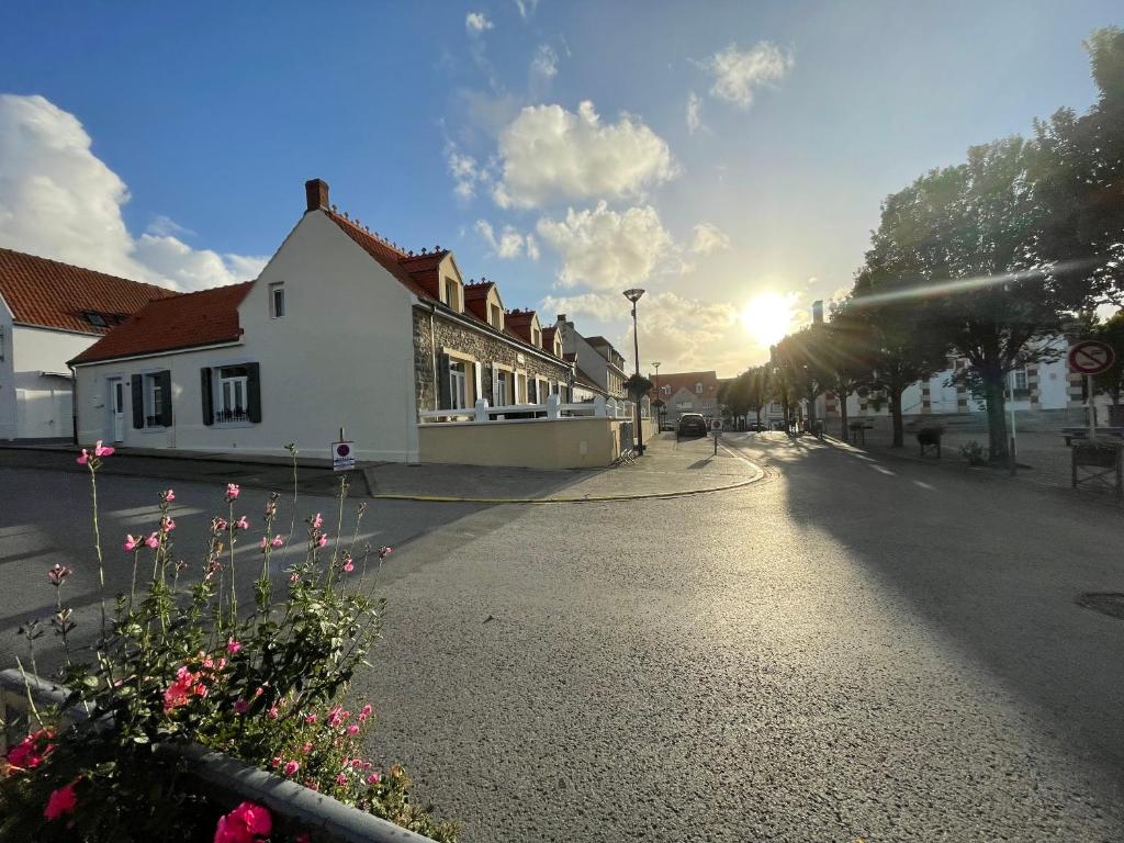a street in a town with the sun setting at Wissant Maison Chez Jeanne in Wissant