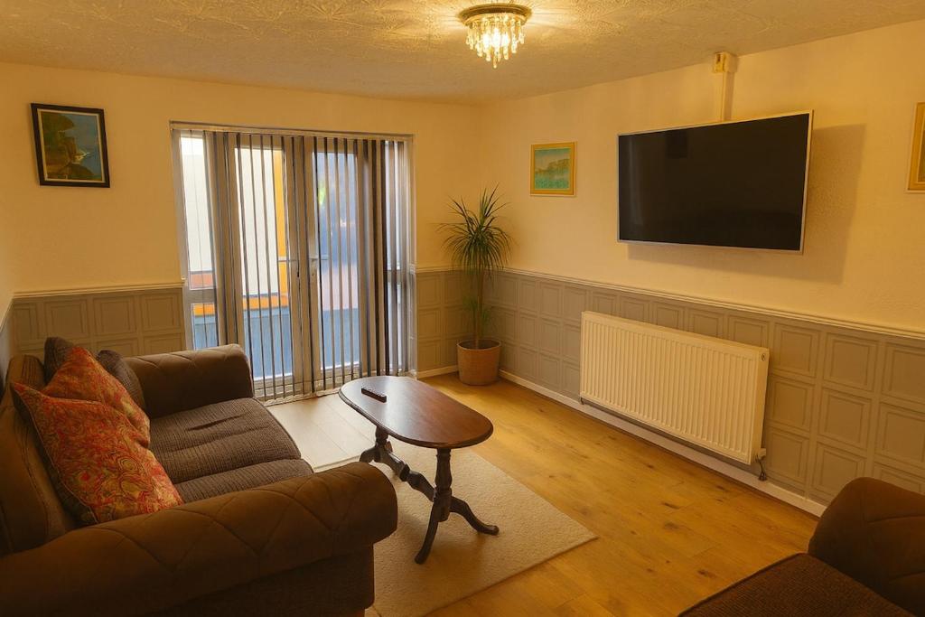 a living room with a couch and a table and a television at Cosy 3 Bed House, Decked Garden, Free Parking in Central Station
