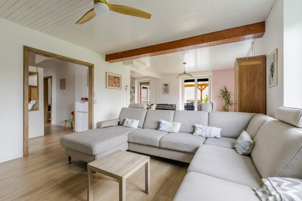 ein Wohnzimmer mit Sofa und Tisch in der Unterkunft Maison Le Nid de Cigognes in Witternheim