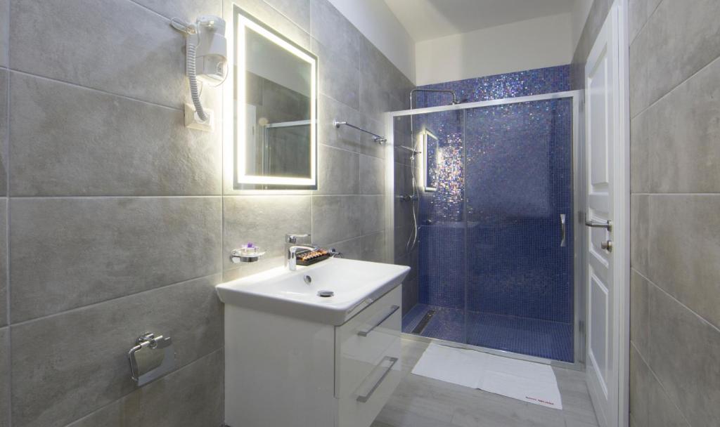 a bathroom with a white sink and a shower at Boutique Hotel Melissa in Poreč