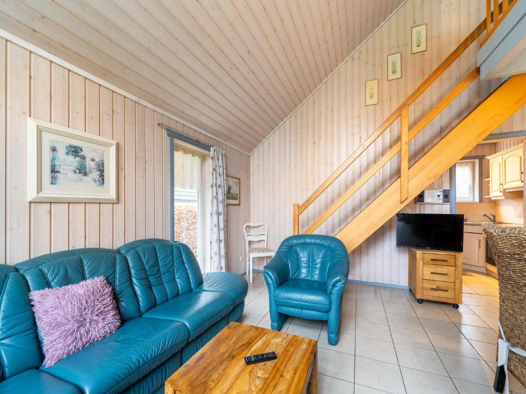a living room with a blue couch and a table at Ferienhaus im Ferienpark Mirow in Granzow
