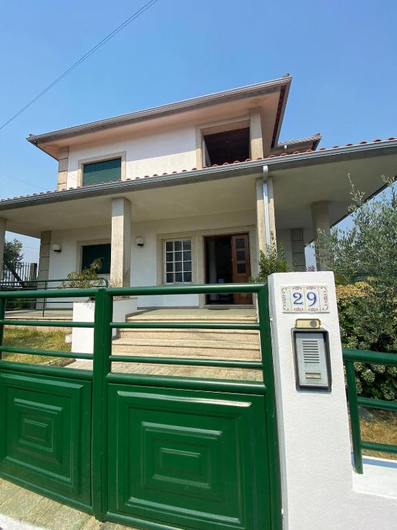 a green and white house with a green gate at Vivenda Juliano Freitas in Atães