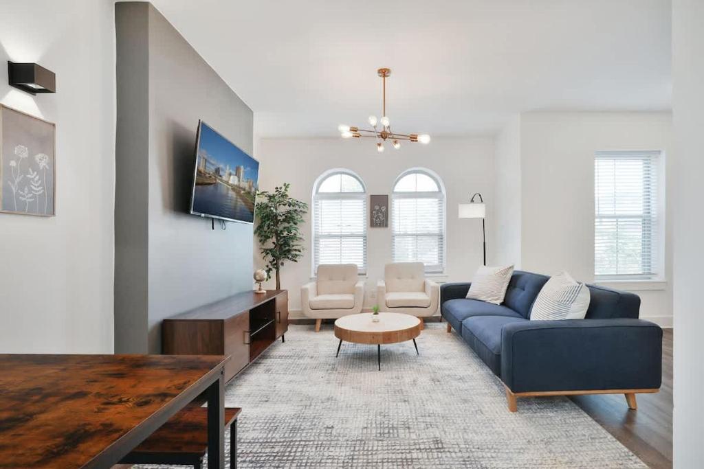 a living room with a blue couch and a table at Contemporary Vintage Home Near Downtown in Bexley