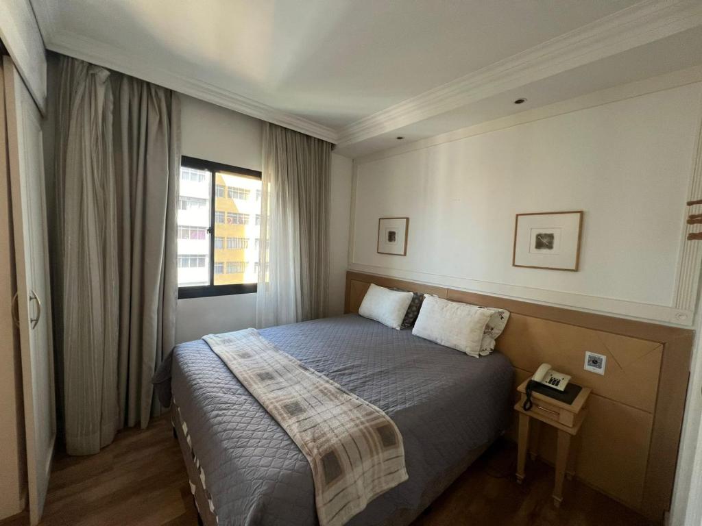 a bedroom with a bed and a window at Hotel Inter Jardins UH1607 in São Paulo